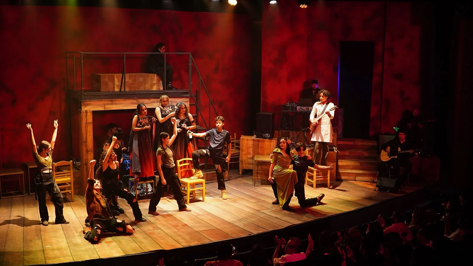 Elenco de CAT compartiendo una escena frente al público